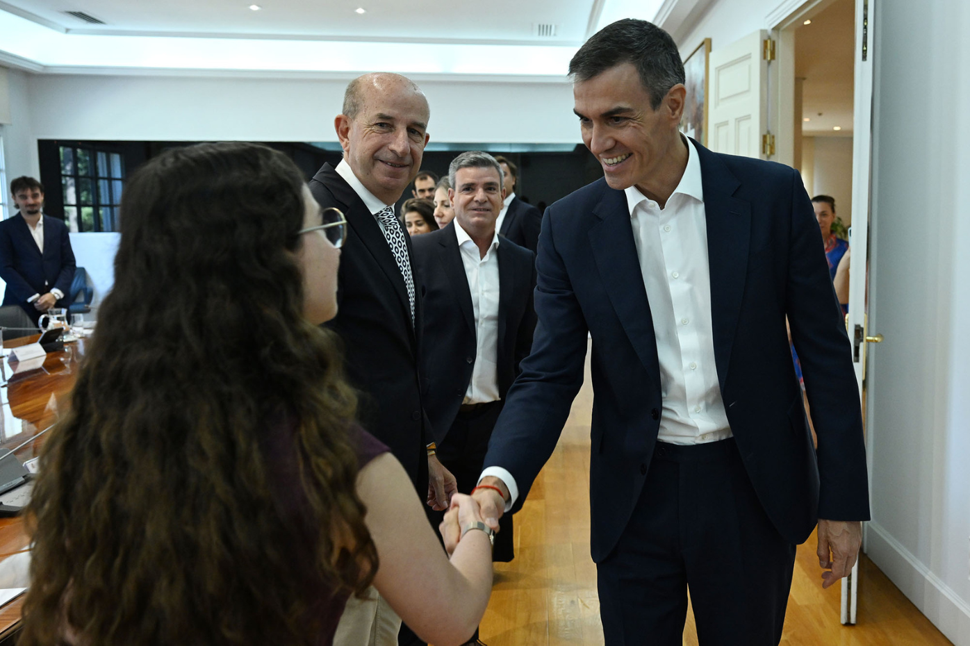 El presidente del Gobierno, Pedro Sánchez, saluda a una de las participantes en la reunión.
