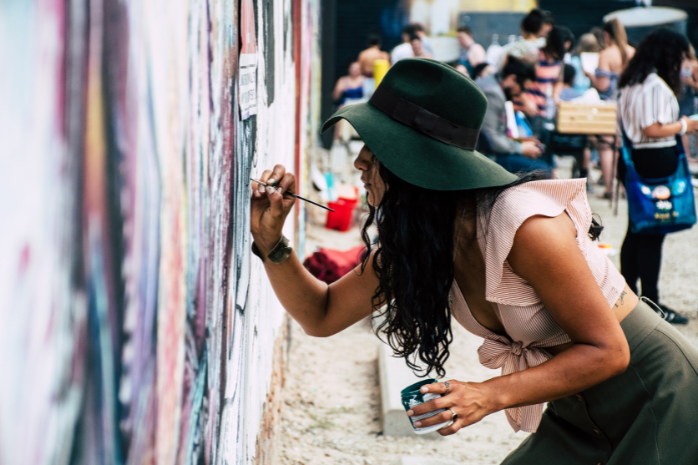 Una mujer pinta un mural