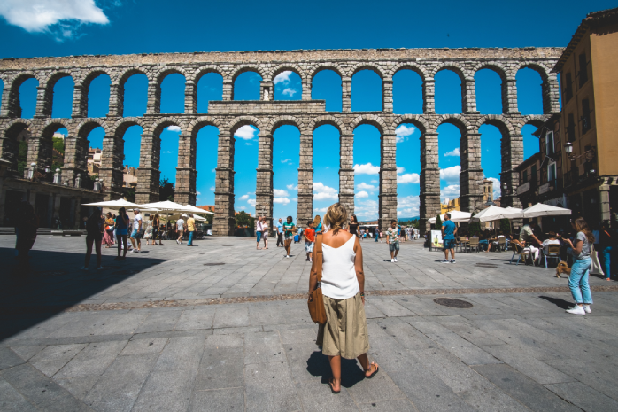 una mujer frente al acueducto de Segovia 