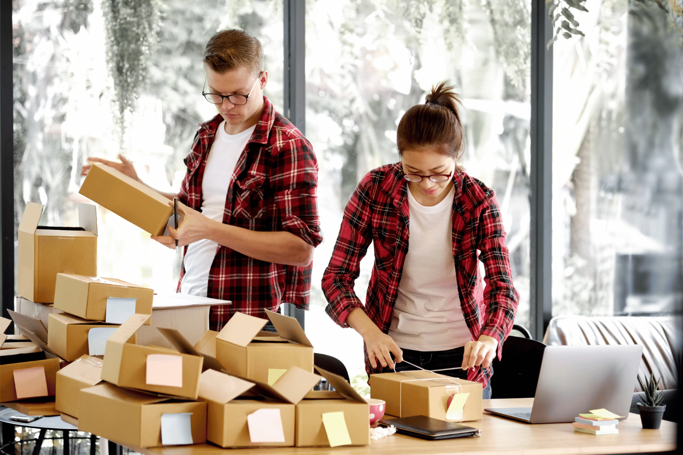 Dos emprendedores organizando cajas para hacer envíos.