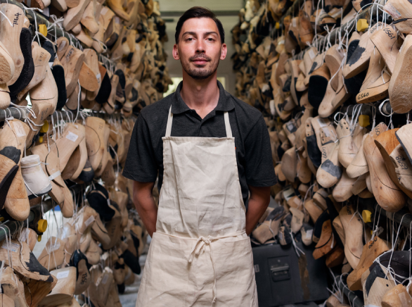 Un hombre posa de frente en un taller artesano de hormas para zapatos