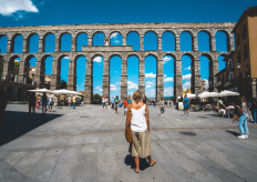 una mujer frente al acueducto de Segovia