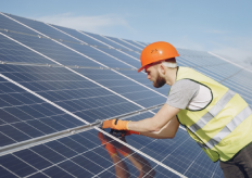 un operario trabajando en una placa solar