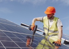 un operario trabajando en una placa solar