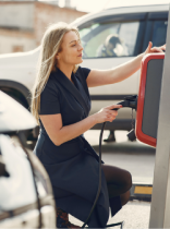 una mujer recargando un coche eléctrico en una estación de recarga