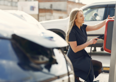 una mujer cargando un coche eléctrico