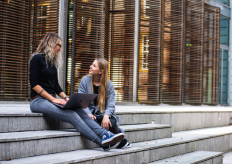 dos jóvenes sentadas en una escalinata