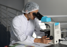 un investigador mirando a través de un microscopio