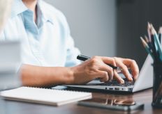 una persona escribiendo en un portátil