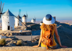 una joven sentada frente a unos molinos