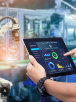 una persona consultando una tablet frente a un brazo robótico