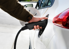 una persona recargando un coche eléctrico