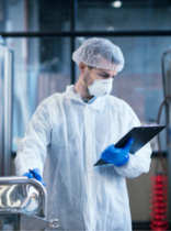 un operario en una industria con una bata blanca