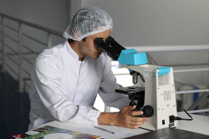 un investigador mirando a través de un microscopio