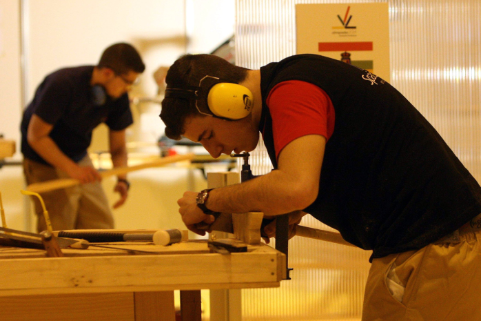 dos jóvenes trabajando en un taller de carpintería