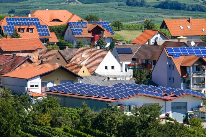 un pueblo con casas con placas solares en los tejados 