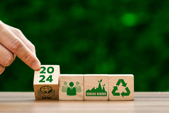 una mano girando cubos con dibujos de logotipos de elementos sostenibles
