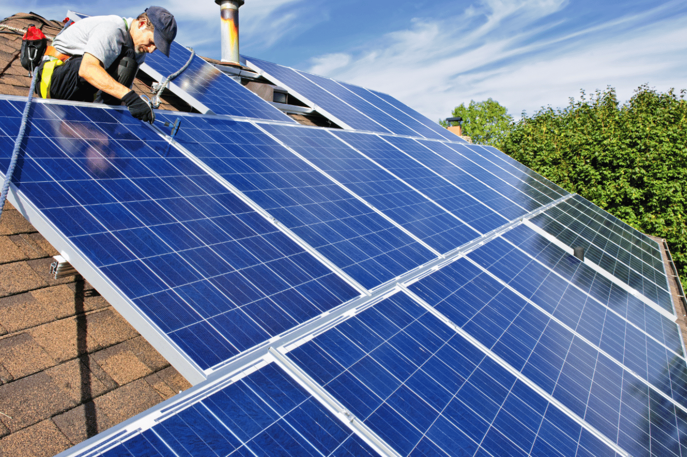 Instalador de paneles solares trabajando en un tejado.