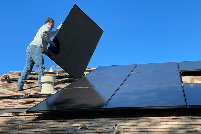 una persona instalando paneles solares en un tejado