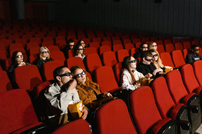 Varias personas en el patio de butacas de un cine con gafas 3D