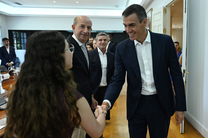 El presidente del Gobierno, Pedro Sánchez, saluda a una de las participantes en la reunión.