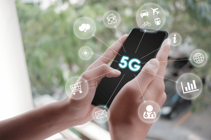Unas manos sostienen un teléfono móvil con las indicación 5G en la pantalla.