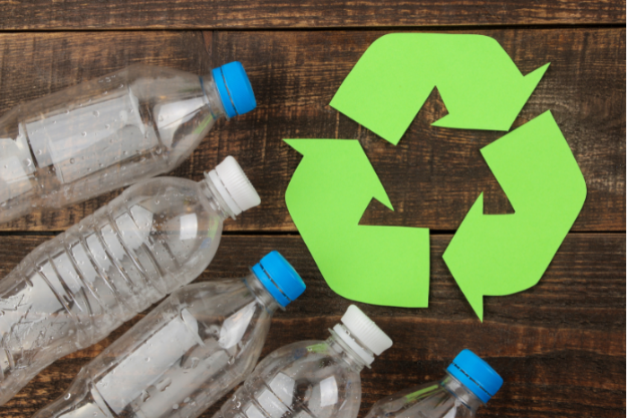 botellas de pl&aacute;stico y un s&iacute;mbolo de reciclaje